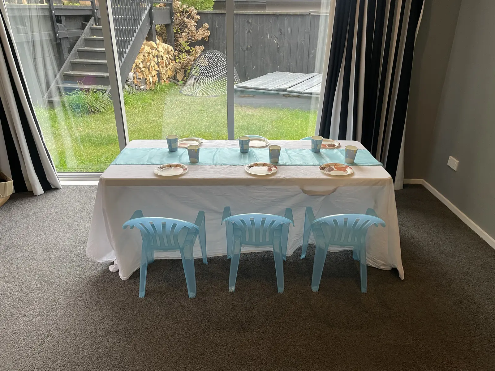 Front view of a children’s table with three light blue Playday chairs.