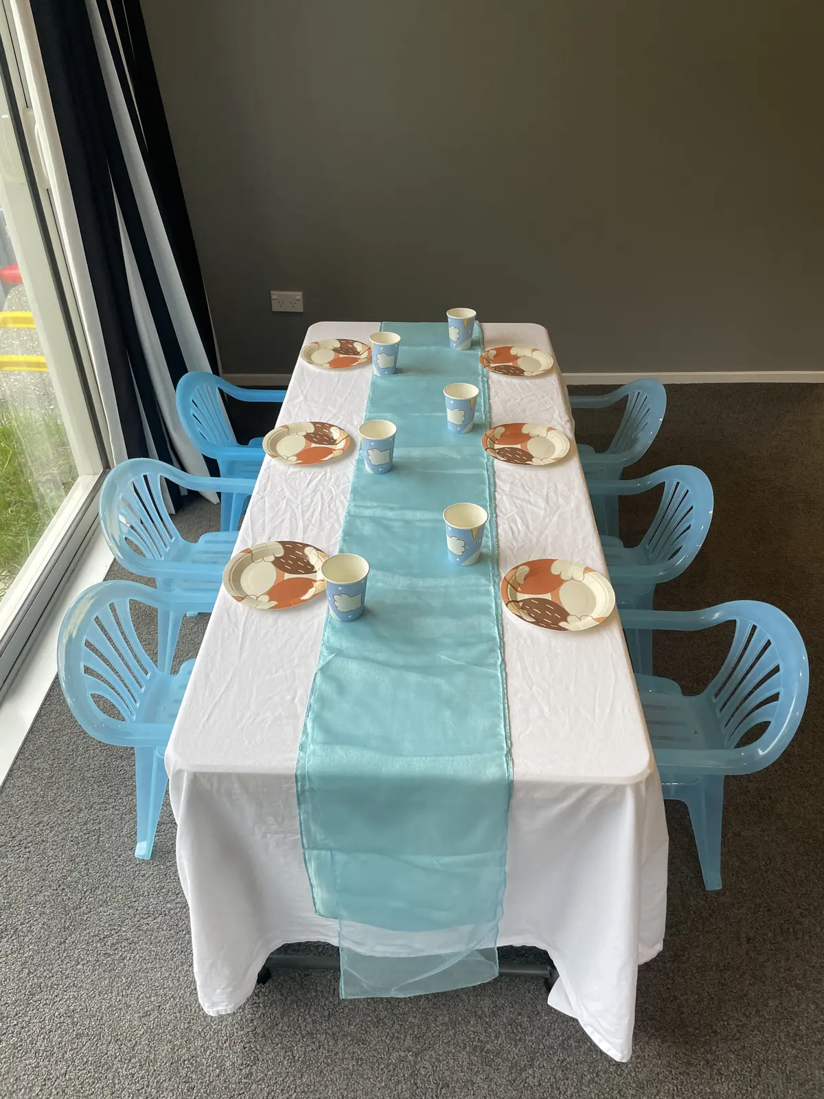 Overhead view of a children’s table with light blue Playday chairs and table settings.