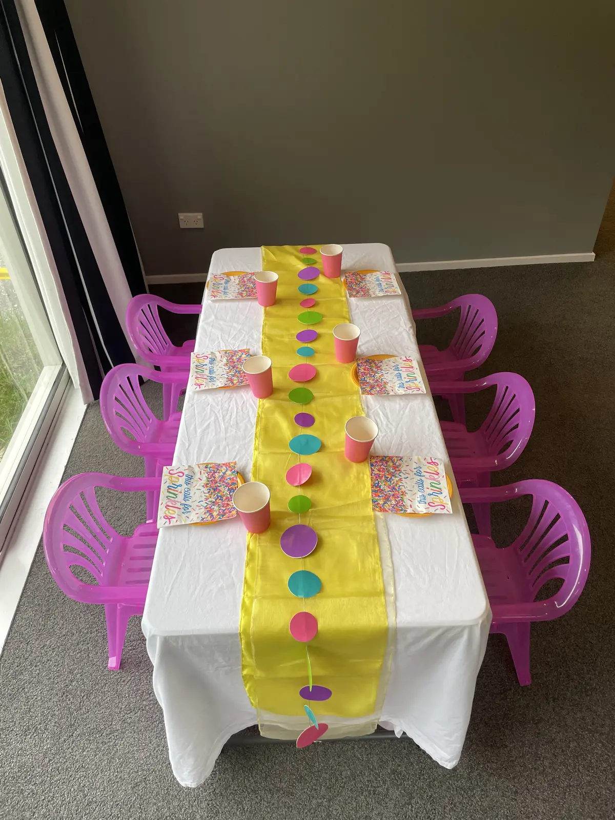 Overhead view of a children’s table with bright pink Playday chairs and colourful styling.