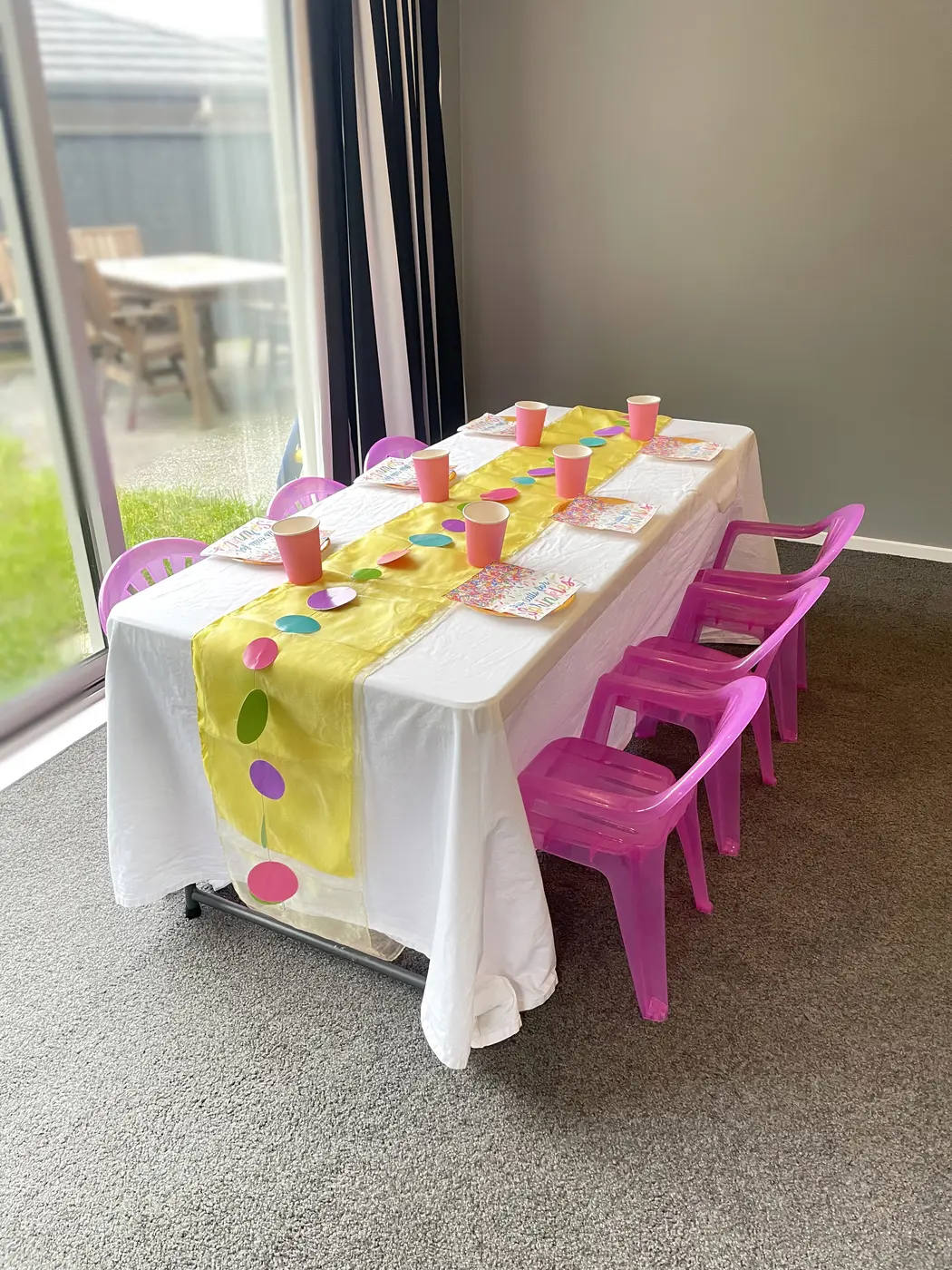 A children’s party table set at child height with Playday’s bright pink chairs.